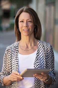 Beautiful confident business woman holding a tablet computer