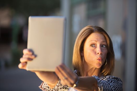 Woman posing for picture for tablet computer self-portrait