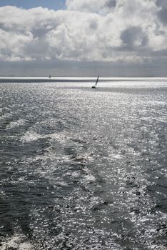 Sun over the Wadden Sea with sailing boat
