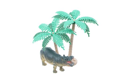 A small toy hippo with trees isolated on a white background.