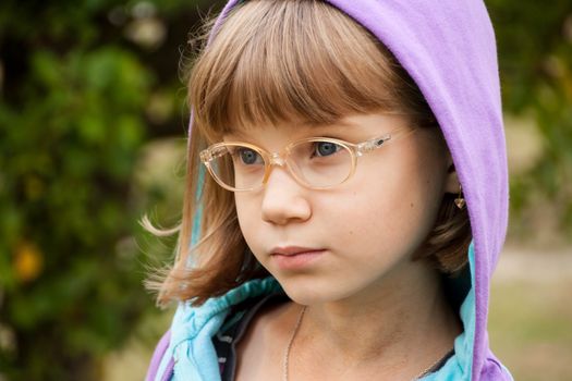 small girl blond in the hood and glasses