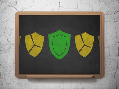 Safety concept: row of Painted yellow broken shield icons around green shield icon on School Board background