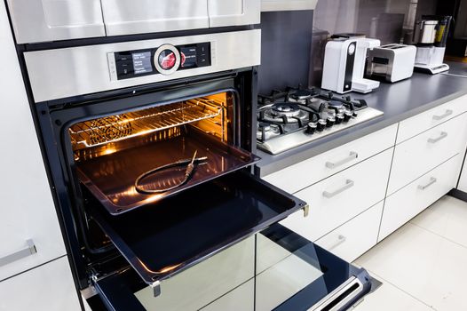 Modern luxury hi-tek black and white kitchen, clean interior design, focu at oven with open door