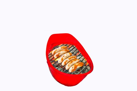 Red hard hat on a white background. In the helmet is burning barbecue fire. sausage it is grilled.