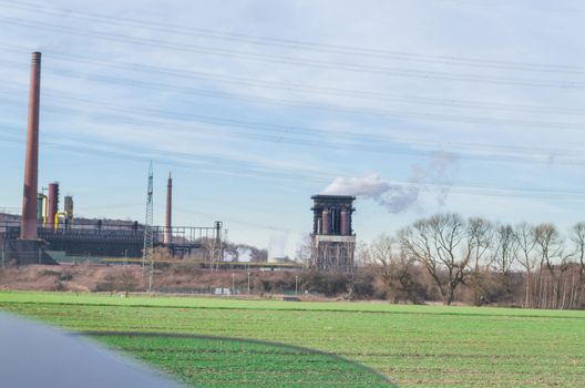 Old power plant on a greenfield site against a blue sky.