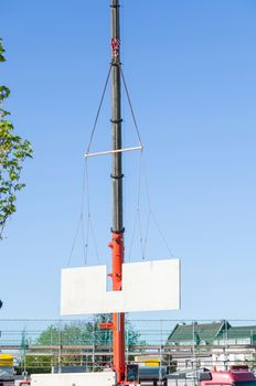 Mobile Crane car on a construction site. Lifts up a concrete wall.