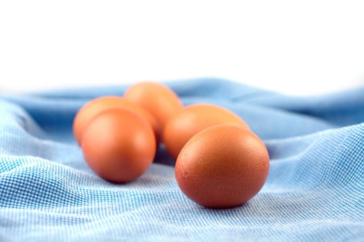 Eggs on blue cloth, select focus on front egg