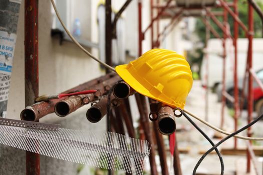 yellow helmet on tubular scaffolding, shallow DOF