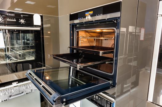 Modern luxury hi-tek black and white kitchen, clean interior design, focus at oven with open door