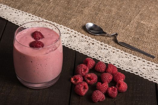 raspberry - banana smoothie on korichnevom the background of natural wood, lace