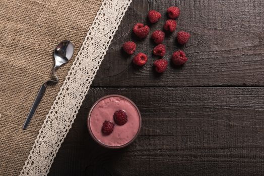 raspberry - banana smoothie on korichnevom the background of natural wood, lace