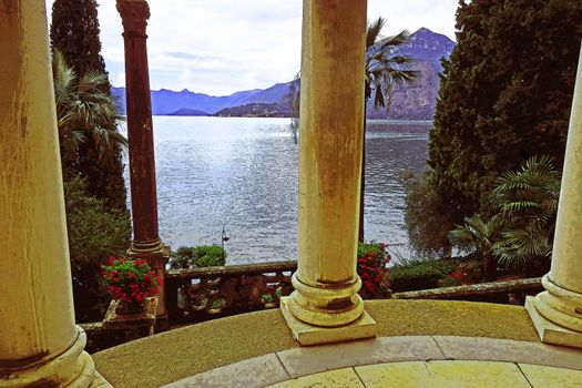 Romantic view of Lake Como between the columns of a temple ornamental in a botanical garden in Varenna, Italy.Retouched with artistic effects
