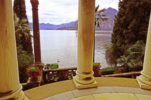 Romantic view of Lake Como between the columns of a temple ornamental in a botanical garden in Varenna, Italy