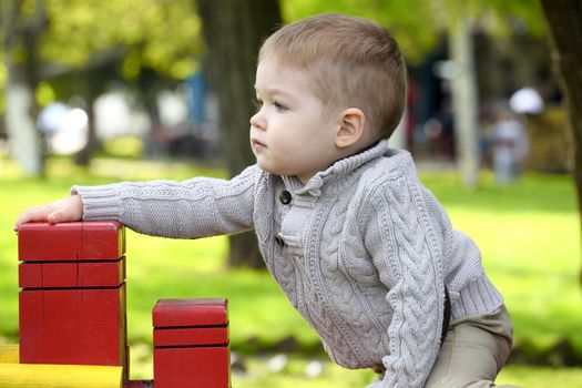 2 years old Baby boy on playground in spring outdoor park 