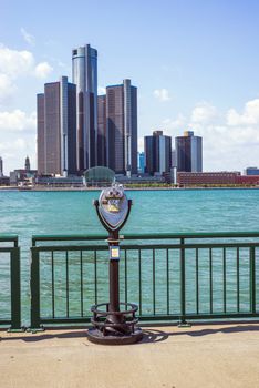 WINDSOR, ONTARIO - AUGUST 16, 2015: Sightseeing tourist binoculars overlooking downtown Detroit with the General Motors Renaissance Center in the background.
