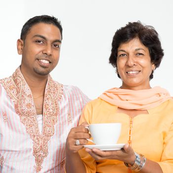 Portrait of happy Indian family at home. Mature 50s Indian mother and 30s grown son.