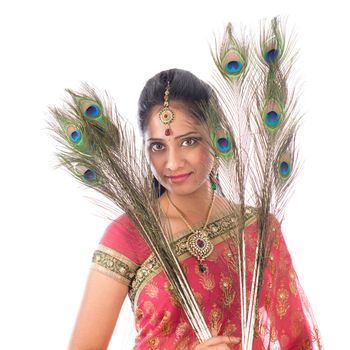Portrait of beautiful young Indian girl holding peacock feathers, isolated on white background.