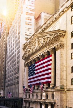 Famous Wall street and the building in New York, New York Stock Exchange with patriot flag