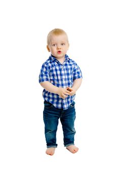 A little boy in a plaid shirt and jeans on white background in full length