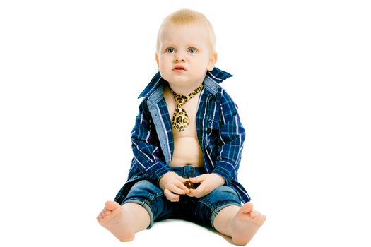 Little dissatisfied boy in a plaid shirt, tie and jeans on a white background