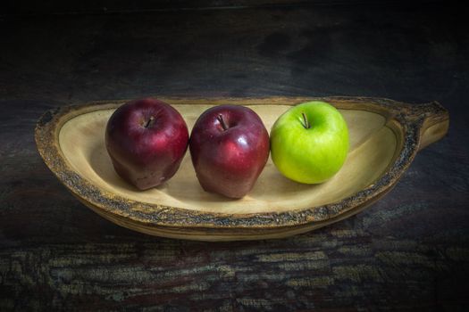 apples in a wooden bowl, dark tone background