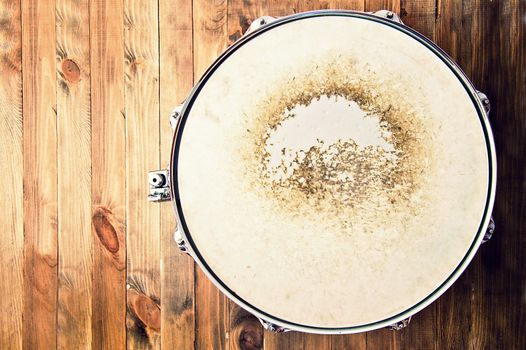 Drums conceptual image. Picture of snare drum lying on wooden background. Retro vintage instagram picture.