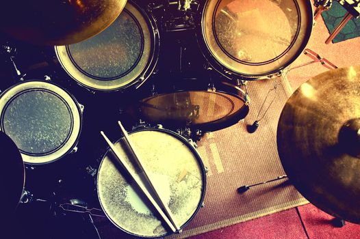 Drums conceptual image. Picture of drums and drumsticks lying on snare drum. Retro vintage instagram picture.