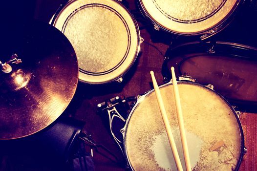 Drums conceptual image. Picture of drums and drumsticks lying on snare drum. Retro vintage instagram picture.