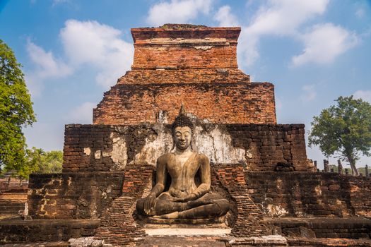 Statue of seated lord Buddha at ancient temple of Wat Mahathat in Sukhothai, Thailand