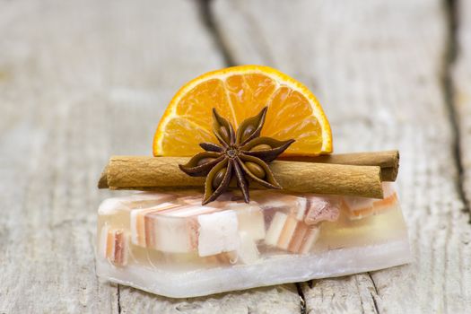 aromatic glycerin soap, orange and spices on wooden background