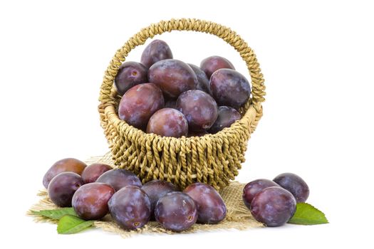 fresh plums in a basket on white background