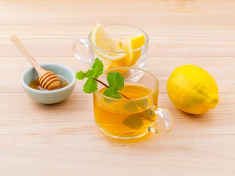 Cup of herbal tea with fresh green mint ,honey and lemon on wooden background.