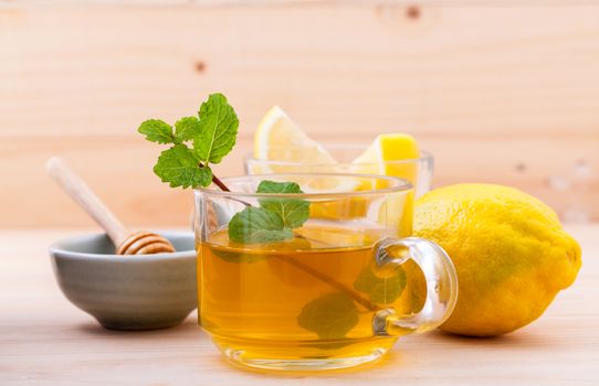 Cup of herbal tea with fresh green mint ,honey and lemon on wooden background.