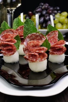 Canape of balls a melon and salami with mint