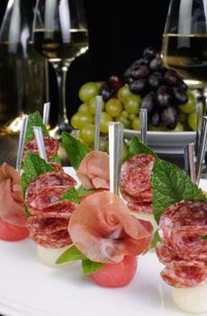 Canape of watermelon balls with a melon with gammon and salami