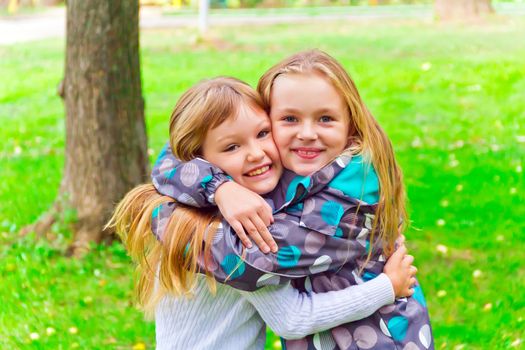 Photo of two embracing girls in summer