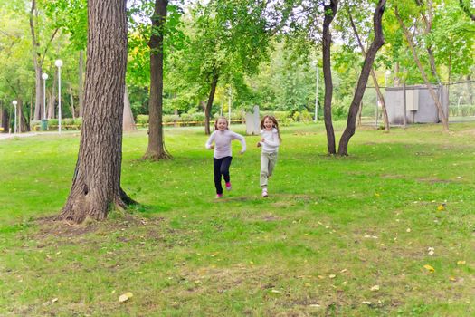 Photo of two running girls in summer