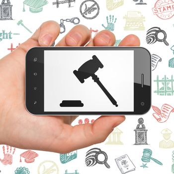 Law concept: Hand Holding Smartphone with  black Gavel icon on display,  Hand Drawn Law Icons background