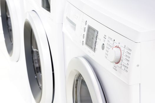 closeup of new white laundry or washing machine, selective focus on control elements