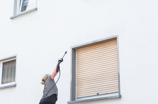 Exterior cleaning and building cleaning a gable wall with high pressure water jet.