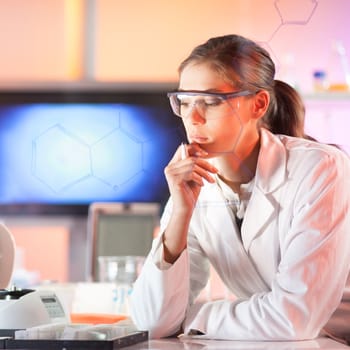 Life science researcher working in laboratory. Portrait of a confident female health care professional in his working environment reviewing structural chemical formula written on a glass board.