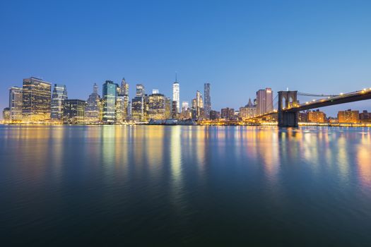 View of New York City Manhattan midtown at dusk with skyscrapers illuminated over east river