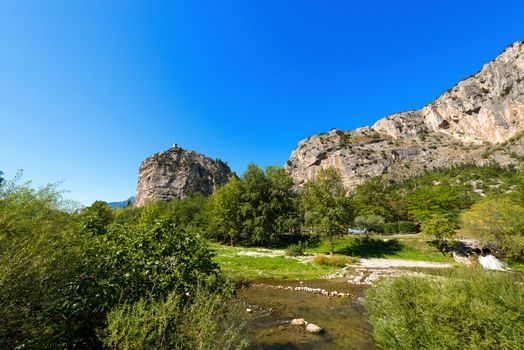 Rock walls with castle in Arco of Trento and Sarca river near the Garda Lake in Trentino Alto Adige, Italy, Europe