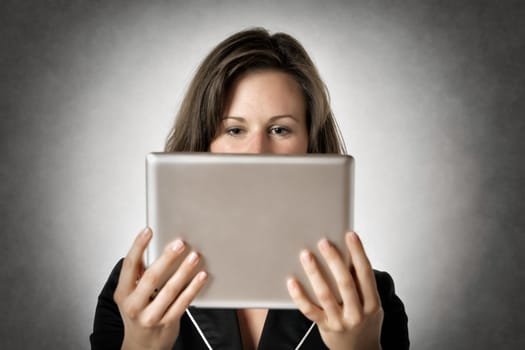 Image of a business woman who looks to a tablet computer