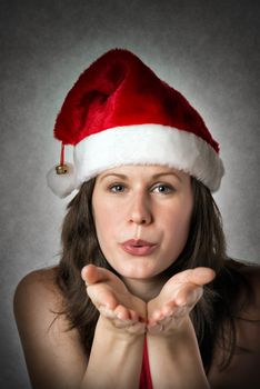 Portrait of a smiling kissing woman wearing Santa Claus costume