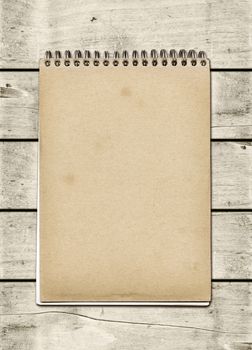 Closed spiral Note book on a white wood table. Mockup