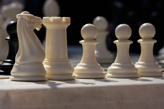 white chess pieces stand ready for battle