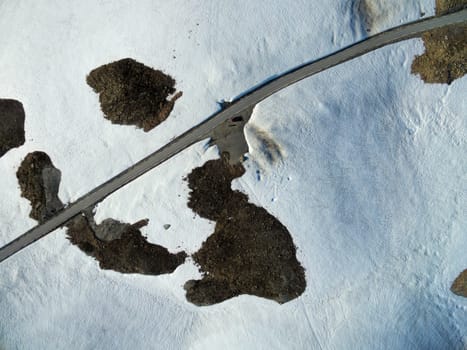 Aerial view of narrow road in snowy landscape of mountain pass Aurlandsfjellet in Norway