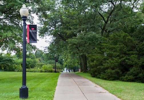 GRINNELL, IA/USA - AUGUST 8, 2015: Wooded path and sign on the campus of Grinell College. Grinnell College is a private liberal arts college  known for its rigorous academics and tradition of social responsibility.