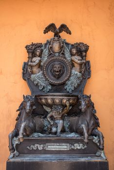 closed up the cupid and horse sculpture with orange wall